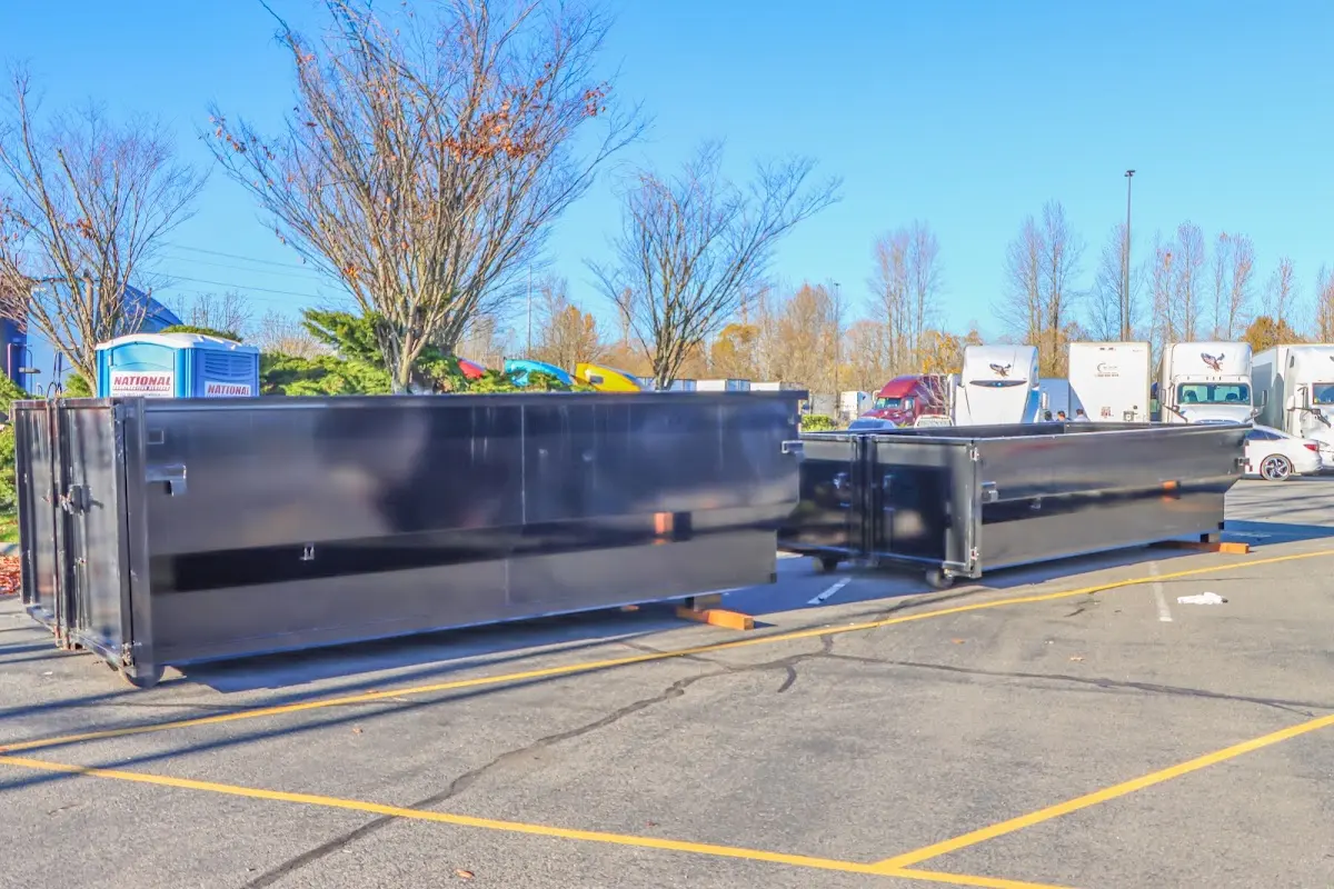 Professional dumpster rental service with roll-off container on residential driveway in Fort Carson